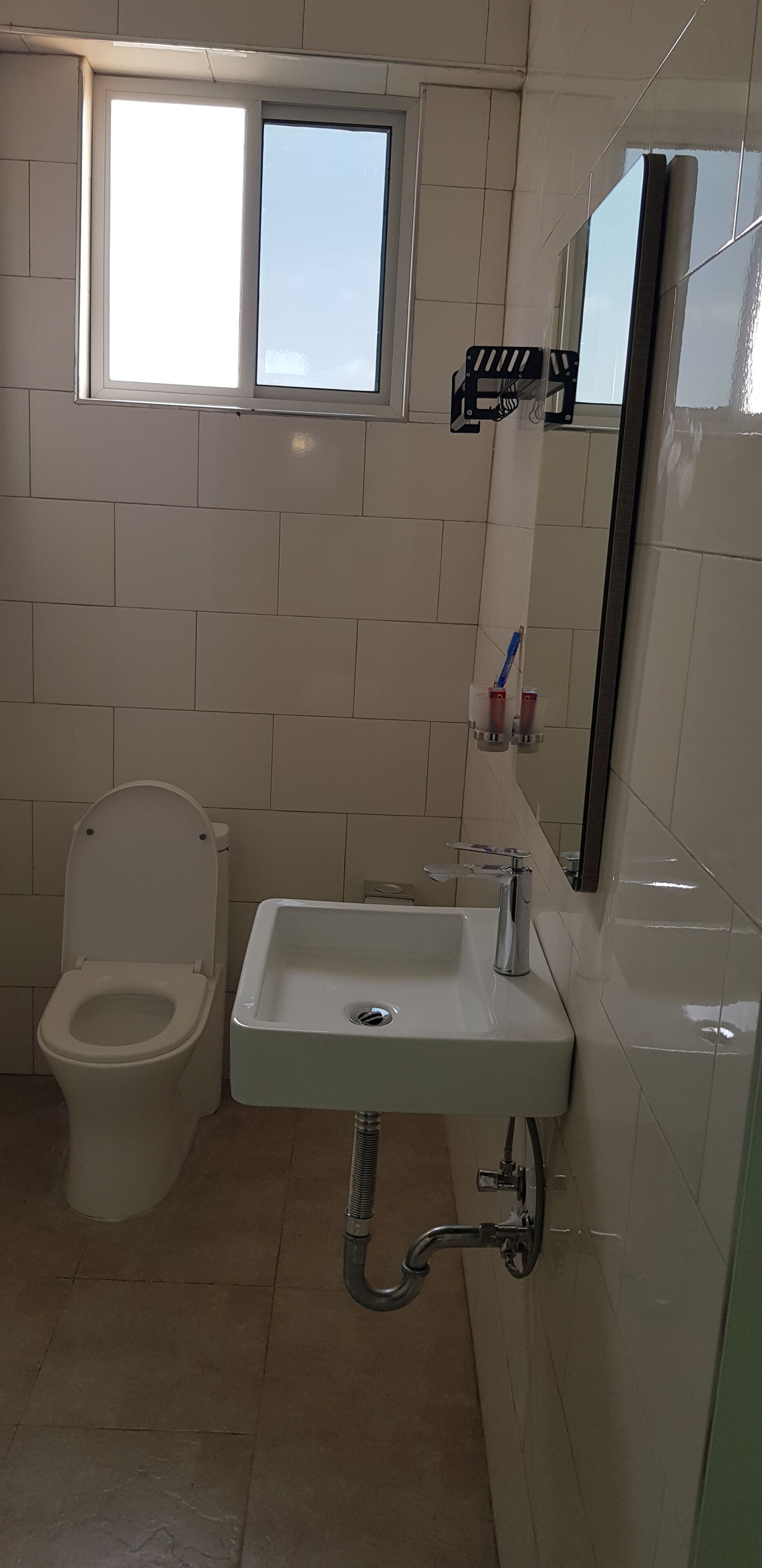 Ein Badezimmer mit Toilette, Waschbecken und Fenster.