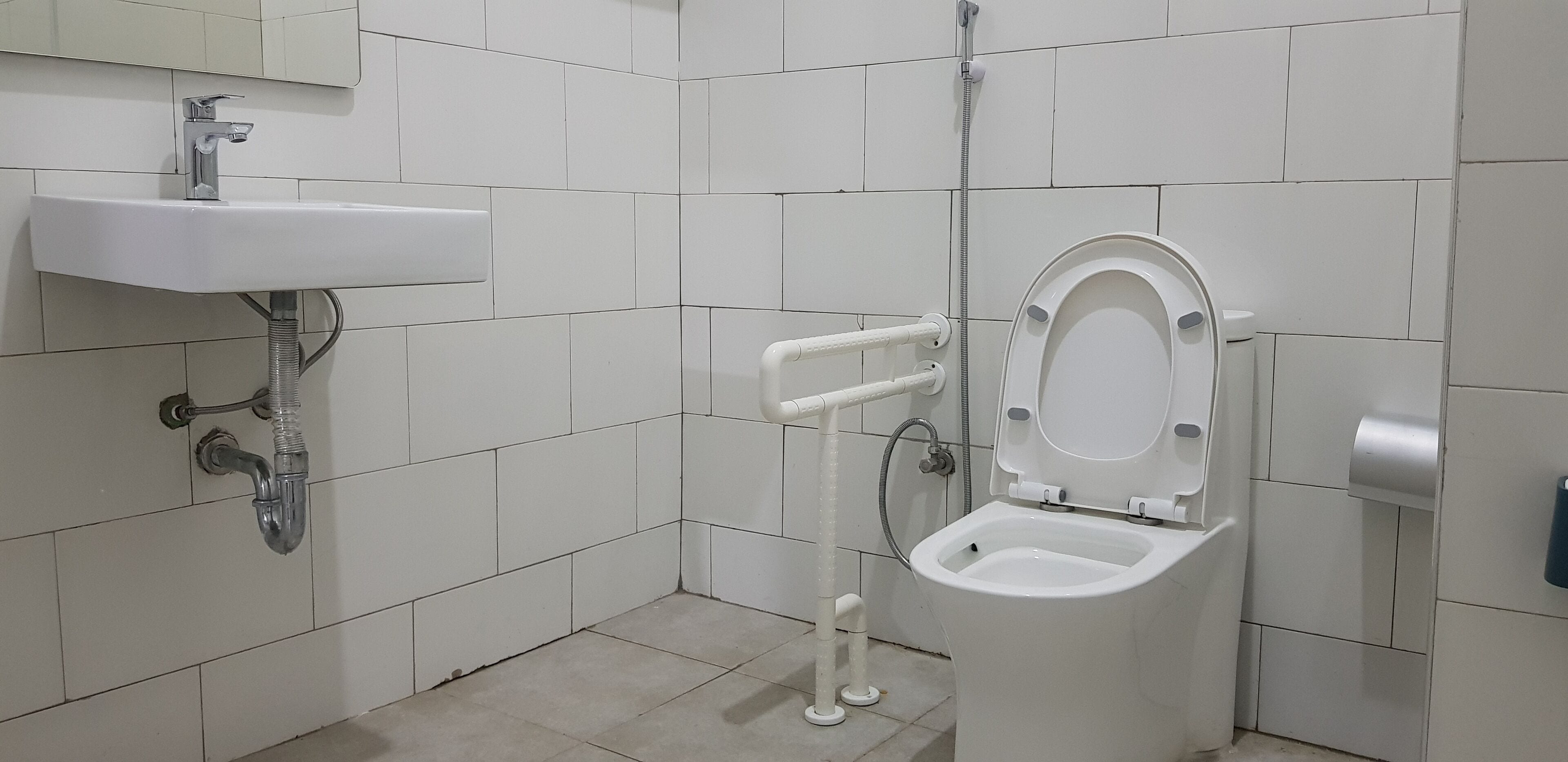 Un bagno con lavandino, WC e doccia, tutti in bianco.