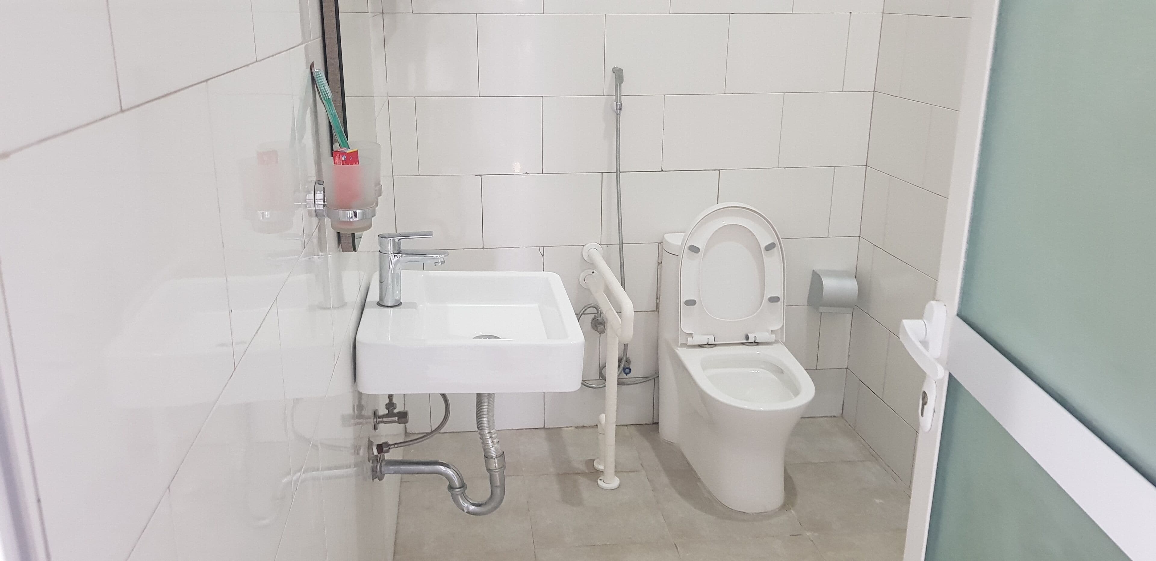 A bathroom with a white sink, toilet, and shower.