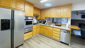 A kitchen with wooden cabinets, stainless steel appliances, and a built-in oven. - Home in Union City
 (Union City)