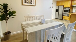 A dining area with a table set for four, a ceiling fan, and a kitchen in the background. - Home in Union City
 (Union City)