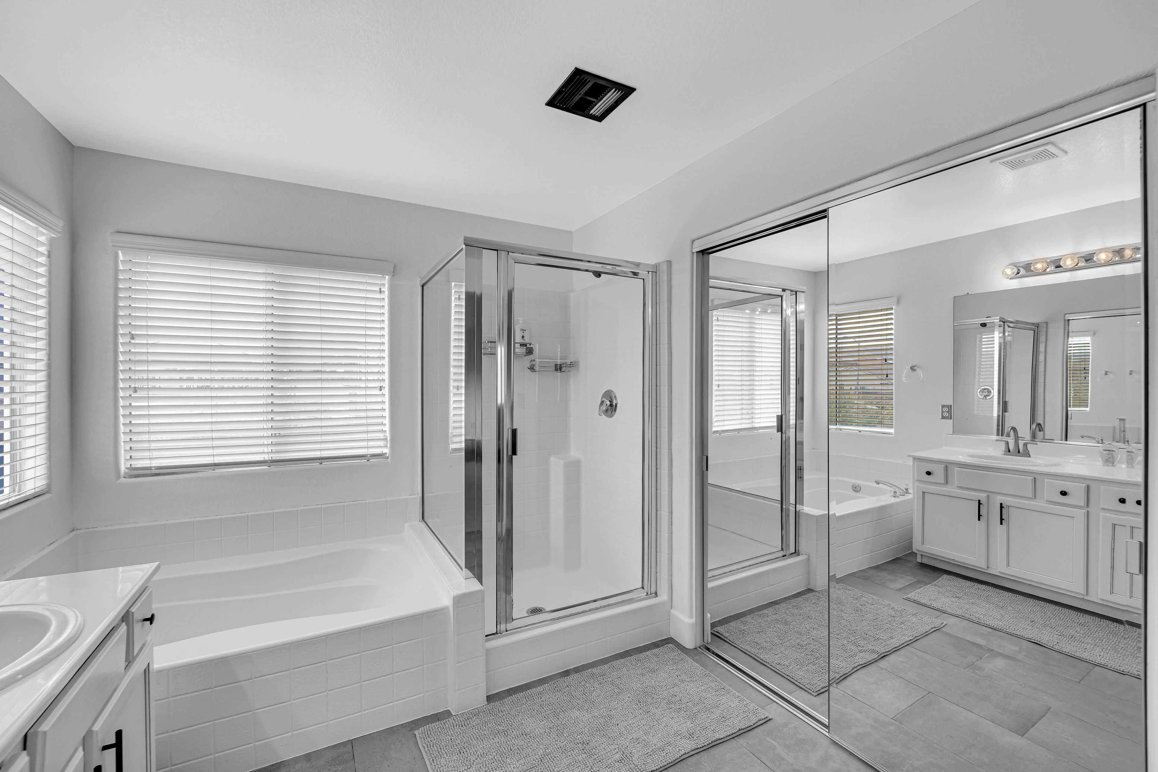 Une salle de bain moderne dotée d’une douche à parois de verre, d’une baignoire sur pieds et d’un meuble-lavabo avec un miroir.