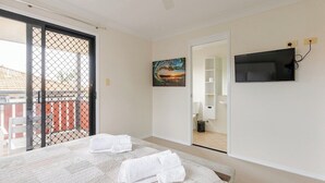 A bedroom with a bed, a TV mounted on the wall, and a painting on the wall. - Happy haven at Eight Mile (Eight Mile Plains)