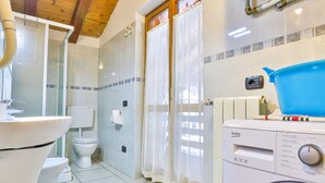 A bathroom with a toilet, sink, shower, and washing machine. - Apartment La Gran Becca - ID 530 (Antey-Saint-Andre)