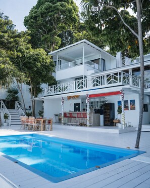 A two-story building with a pool, outdoor seating, and a bar area. - Casa De Lipe Pool Villa (Koh Lipe)