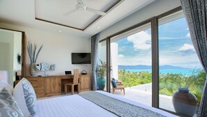 A modern bedroom with a large bed, a desk, and a TV. It has a view of the ocean and mountains. - Villa Shade of Blue  (Koh Samui)