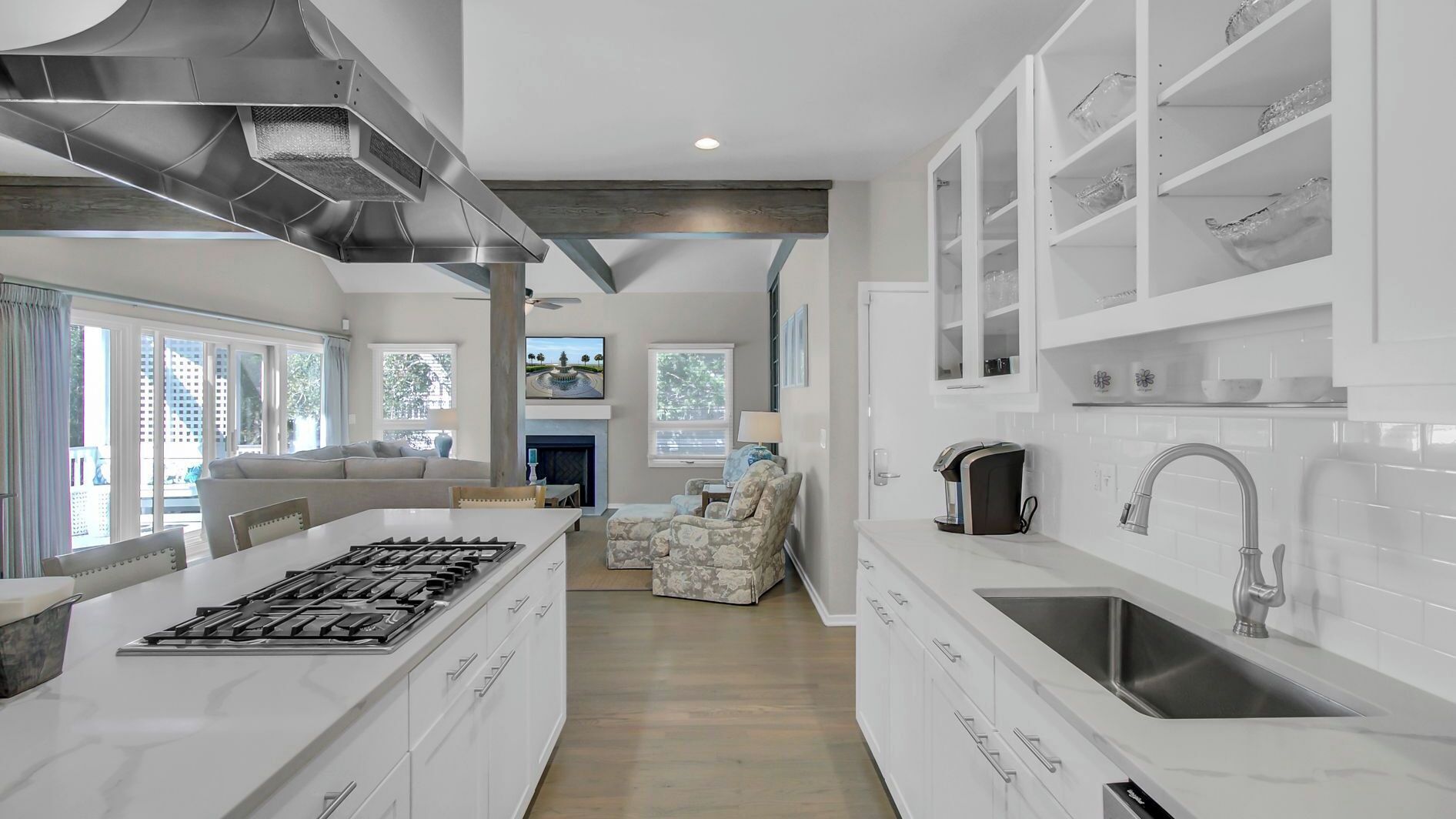 A modern kitchen with a central island, a dining area with a sofa, and a living room with a fireplace.