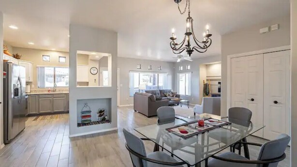 A modern kitchen with a built-in refrigerator, a dining area with a glass table and chairs, and a living room with a sofa and a fireplace. - Perfect for long-term stay, heated Pool, Spa, Gym  (Oro Valley)