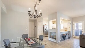 A modern kitchen with a central island, a dining area with a glass table, and a living space with a sofa. - Perfect for long-term stay, heated Pool, Spa, Gym  (Oro Valley)