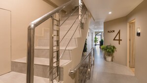Un interior moderno con una escalera, una planta en maceta y un letrero que indica 'Piso 4'.