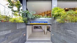 A modern building entrance with a sign indicating 'basement parking' and a height clearance of 7'6".