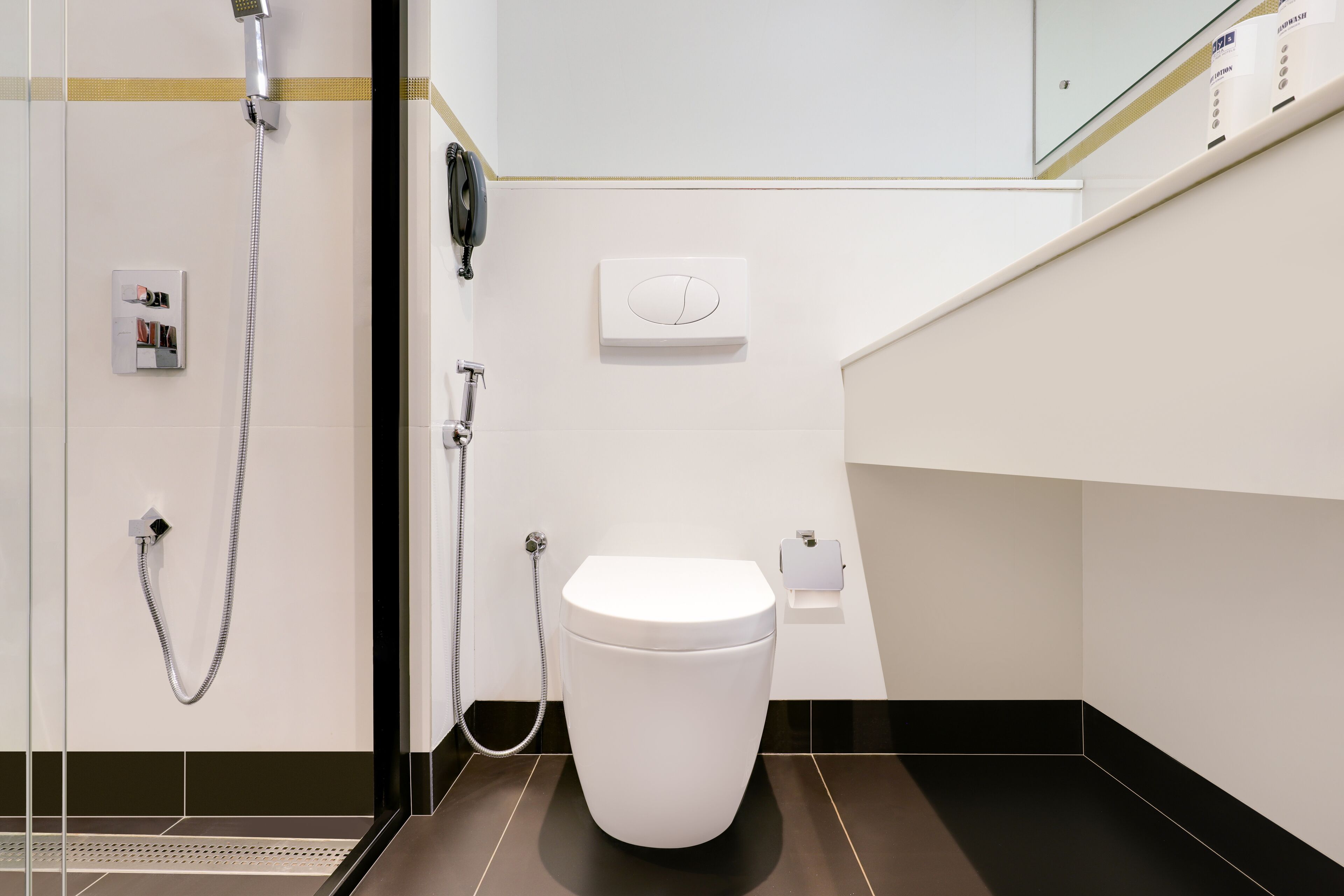 Un baño moderno con inodoro, ducha y secamanos.