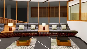 A modern living room with a sectional sofa, wooden side tables, and a large window.