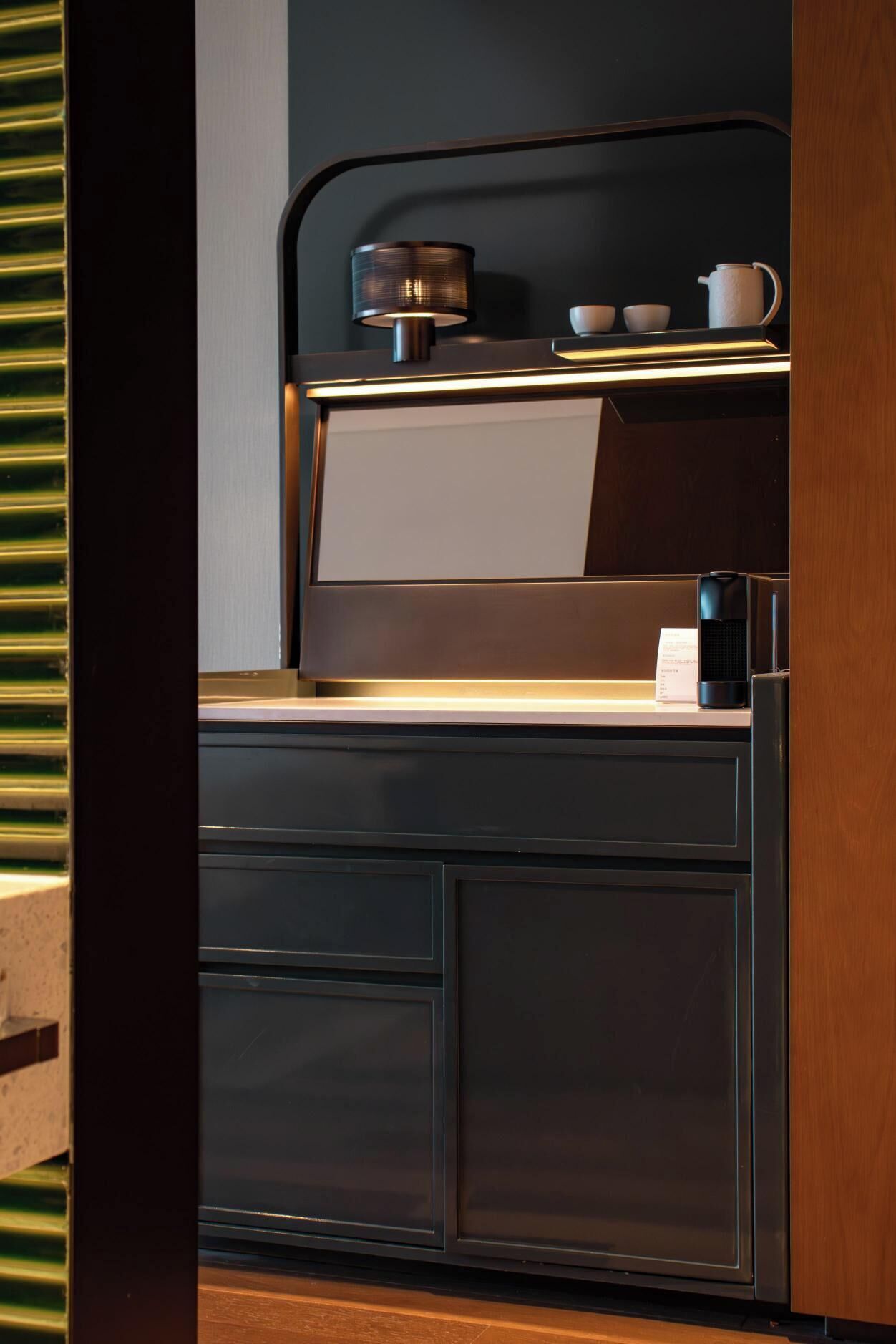 Una cocina moderna con encimera oscura, una cafetera y un hervidor.