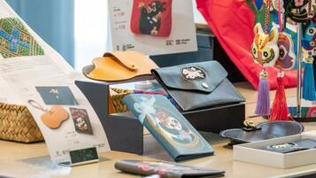 Se exhiben diferentes bolsos y accesorios, incluyendo un bolso de mano rojo, una cartera negra y un bolso tejido.