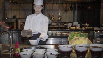 Un chef en una cocina profesional, con diversos utensilios de cocina e ingredientes.