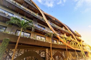 A multi-story building with balconies adorned with plants, a modern architectural design, and a clear sky. - Estudio Asteroide- prime location! (Tulum)