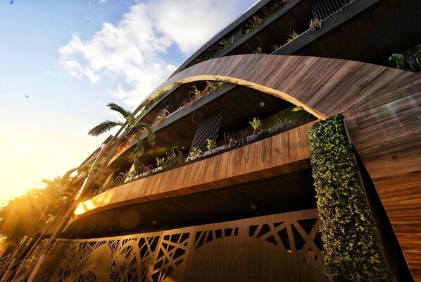A modern building with curved wooden balconies and vertical gardens. - Estudio Asteroide- prime location! (Tulum)