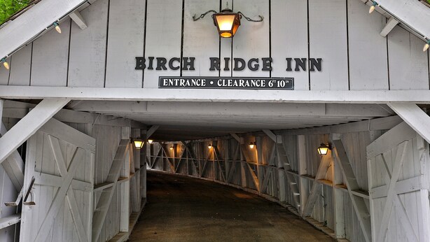 The entrance to Birch Ridge Inn with a sign indicating clearance of 6'10". - The Birch Ridge: English Gentleman's Room #9 - King Suite In Killington, Vermont. Hot Tub. 1 Bedroom Home (Killington)