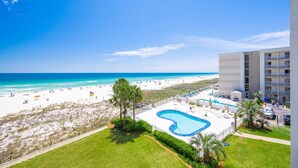 A hotel with a pool, beach view, and a building with balconies. - Breakers 43 2 Bedroom Condo (Orange Beach)