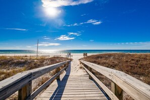 A wooden boardwalk leading to a beach with a clear sky and the sun shining. - Breakers 43 2 Bedroom Condo (Orange Beach)