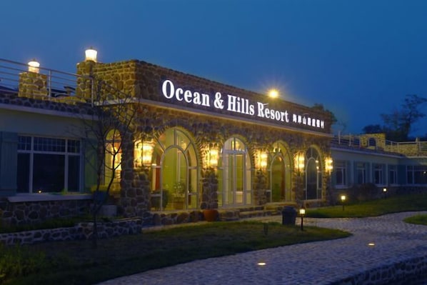 Ocean & Hills -lomakeskuksen ulkoasu: kivestä rakennettu arkkitehtuuri ja kaarevat ikkunat.