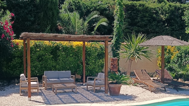 A pool area with a wooden pergola, lounge chairs, and a thatched umbrella. - Apartment in villa with private pool and garden, 3 bedrooms, warm welcome.  (ANTIBES)