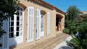 A building with white shutters, a tiled roof, and a gravel pathway. - Apartment in villa with private pool and garden, 3 bedrooms, warm welcome.  (ANTIBES)