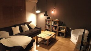 A cozy living room with a sofa, a coffee table, and a bookshelf. - MODERN APARTMENT IN THE CENTER (Vilanova i la Geltrú)