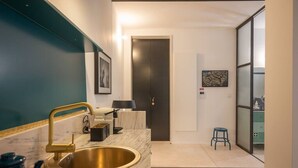 A modern bathroom with a gold sink, a mirror, and a towel rack. - TOUCHY PORTO - Charming apartment located at Praça da Republica (Porto)