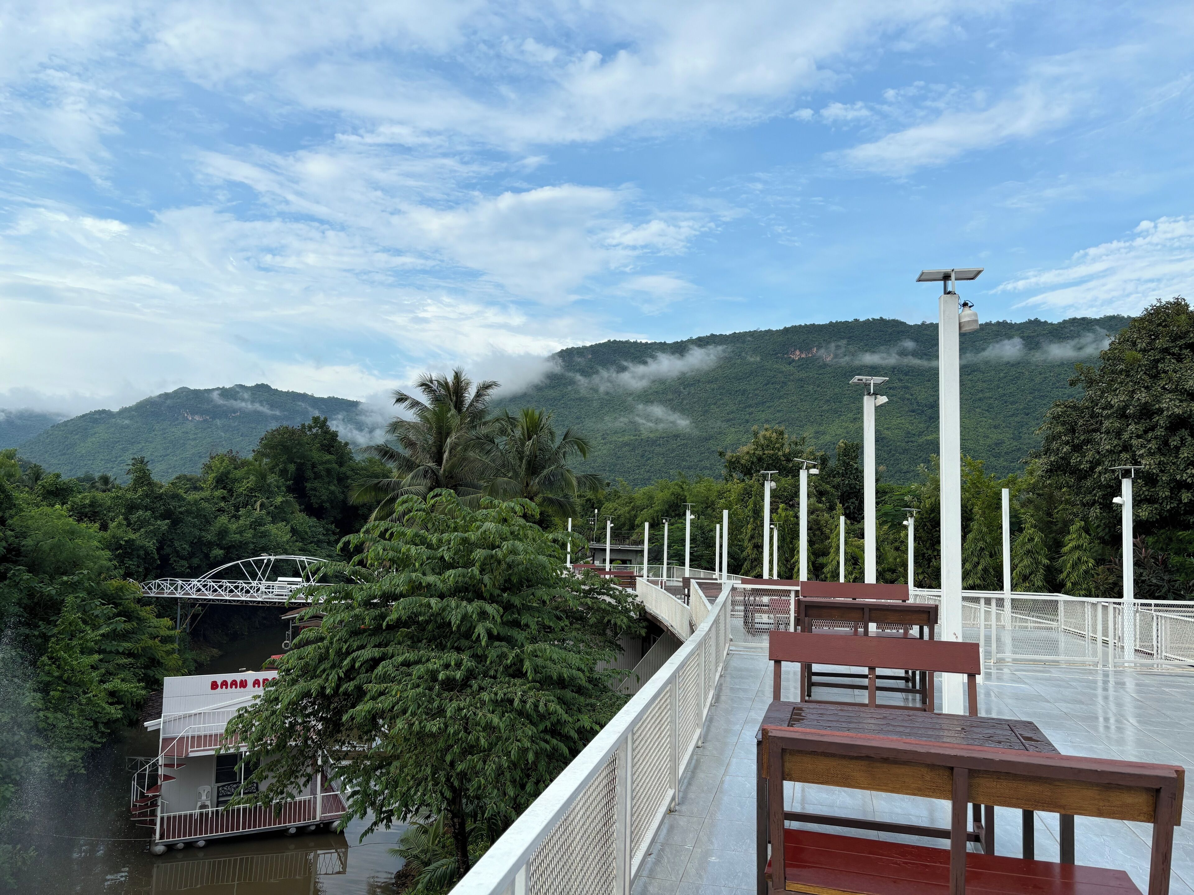 Eine Brücke mit Blick auf einen Fluss und Berge im Hintergrund.