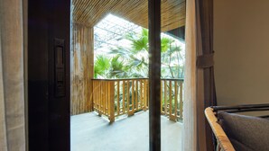 A room with a view of a balcony, a wooden chair, and a door. - 515 VICTORY Hotel (Bangkok)