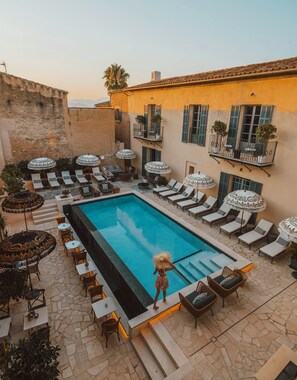 A poolside area with lounge chairs, umbrellas, and a person by the pool. - Ten Mallorca - Adults Only (Sineu)