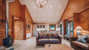 A log cabin interior with a living room, a kitchen, and a dining area.