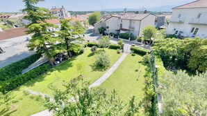 A residential area with a well-maintained lawn, a paved pathway, and surrounding houses. - Apartment Reful (Kraljevica)