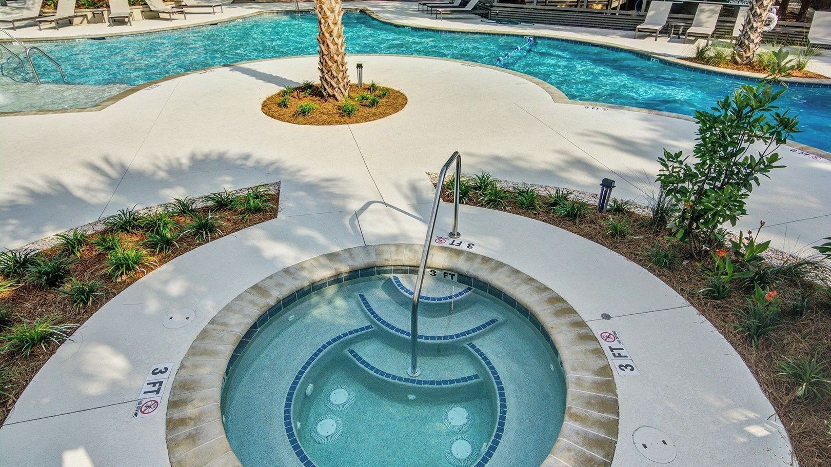 A hot tub with a 3 FT depth marker, surrounded by a pool area with lounge chairs and a palm tree.