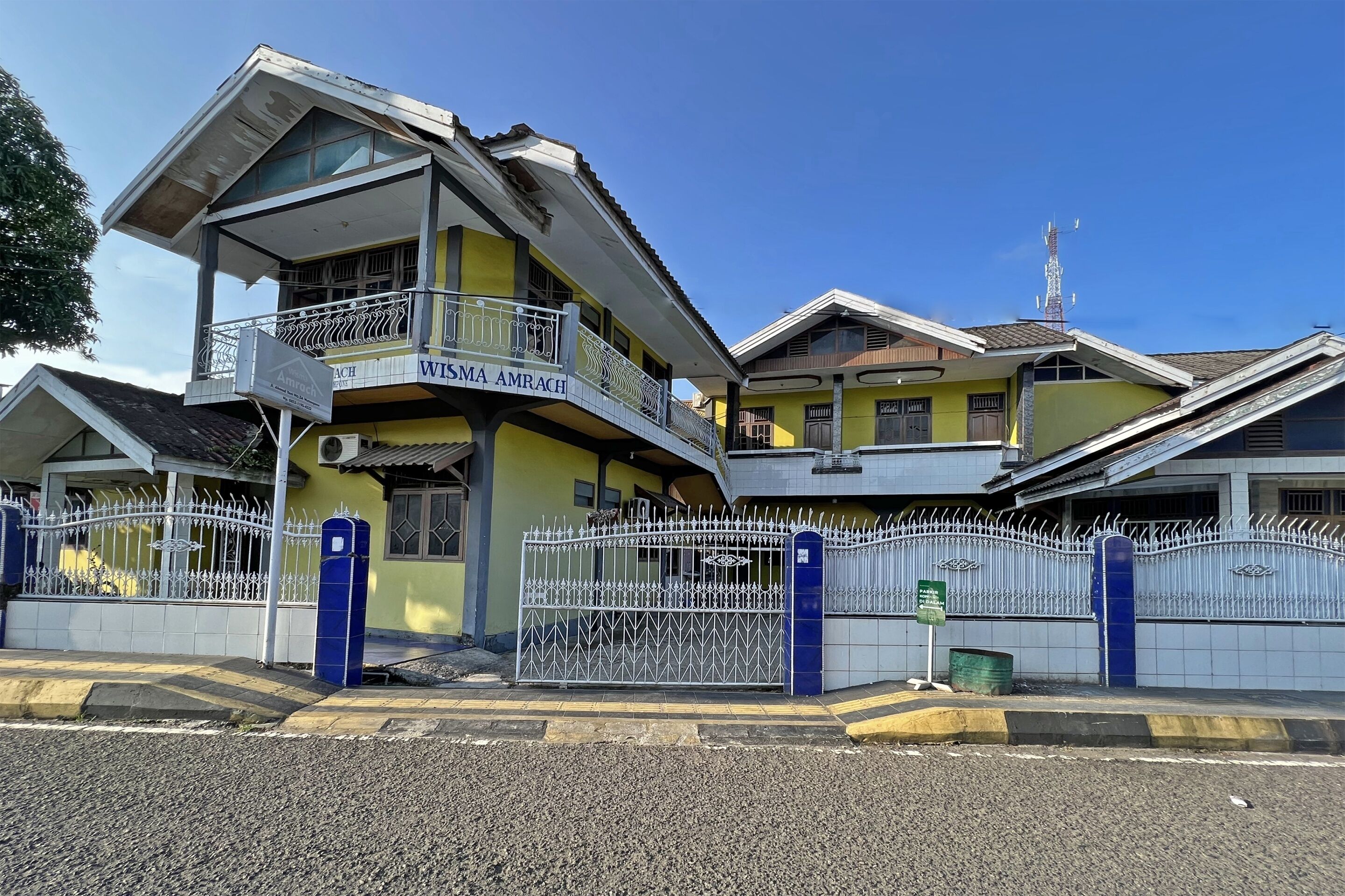 A multi-story building with a balcony and a gated entrance.