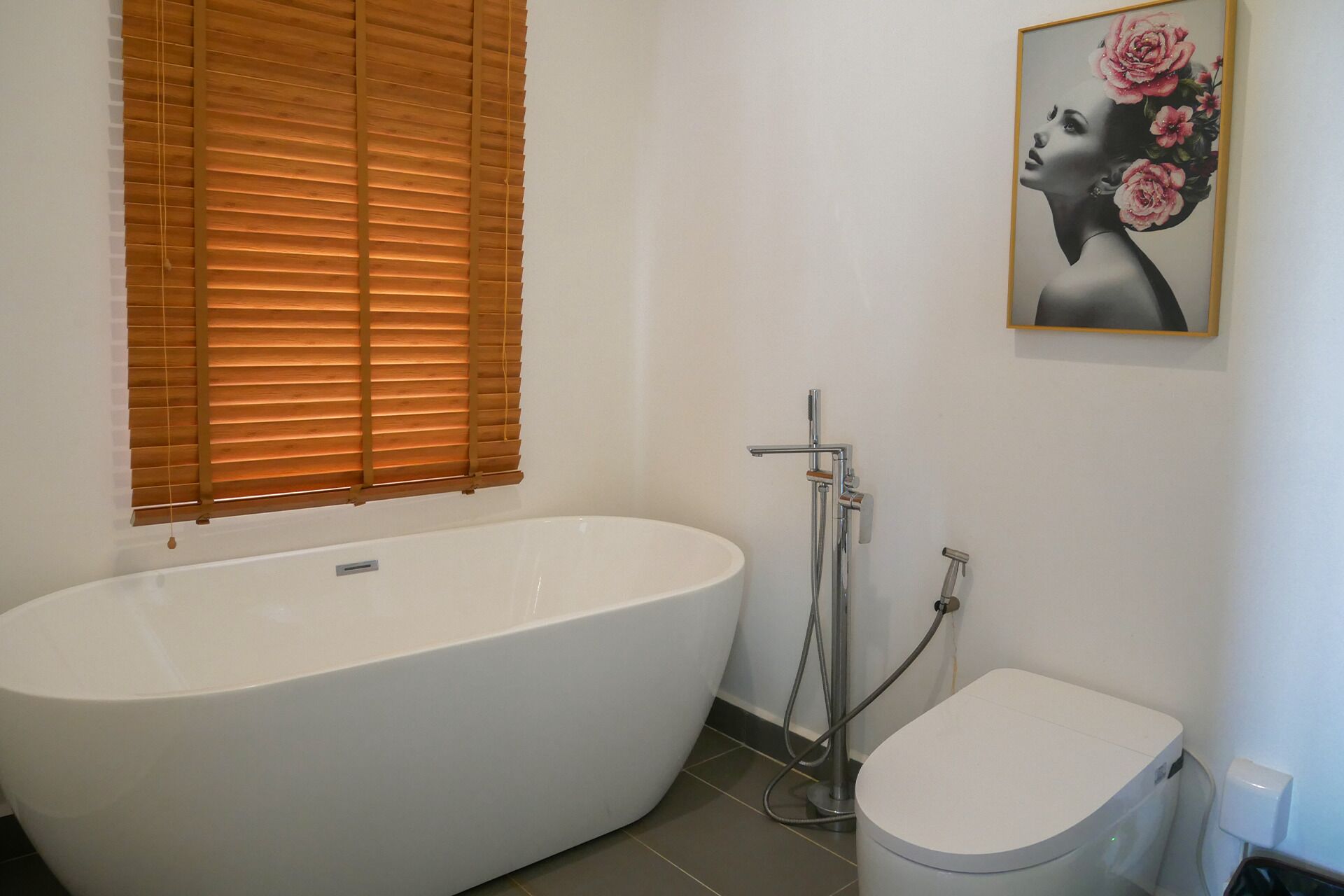 A bathroom with a freestanding bathtub, a toilet, and a shower.