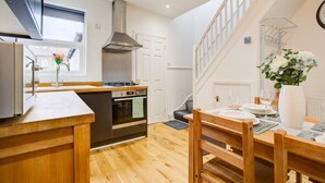 A modern kitchen with wooden countertops, a built-in oven, and a stainless steel range hood.