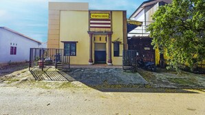 A building with a sign reading "Wisma Idola" and a gated entrance.