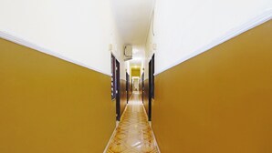 A hallway with yellow walls and a patterned floor.