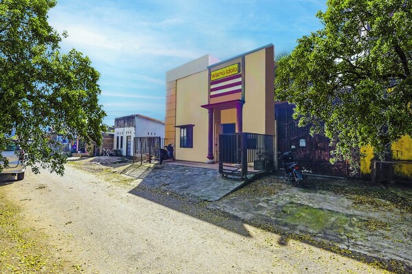 A building with a sign reading "Wisma Idola" and a paved entrance area.
