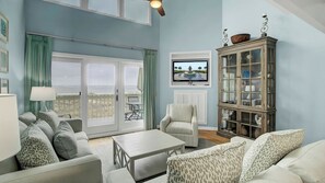 A living room with a large window, a television, a cabinet, and a chair.