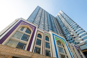 A tall building with multiple floors and a mix of architectural styles, including traditional and modern elements. - OYO 3691 Apartment Saladin Mansion (Depok)