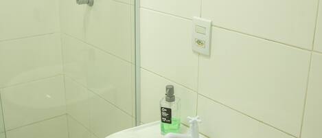 A bathroom with a white sink, a mirror, and a shower.