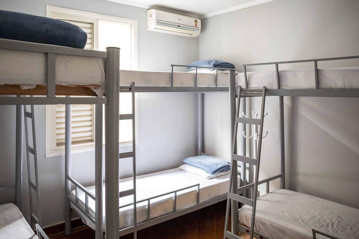 Una camera con un letto a castello, una finestra e un tavolino.
