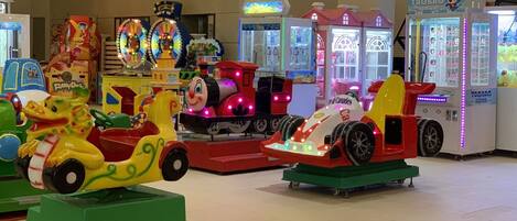 An indoor amusement area with various rides and arcade machines.