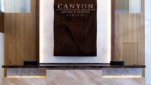 A reception desk with a sign reading "CANYON HOTELS & RESORTS BORACAY". - Canyon Hotels & Resorts Boracay (Boracay Island)