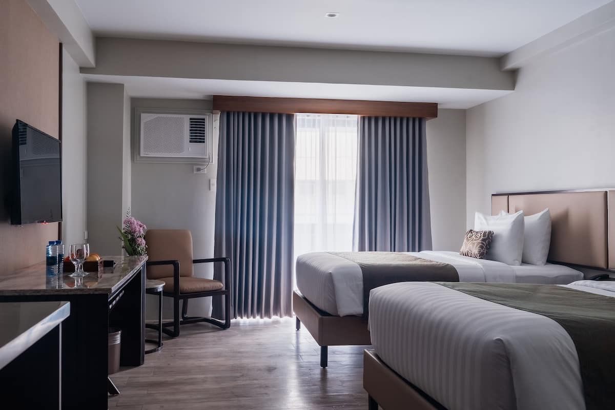 Ein Hotelzimmer mit Bett, Schreibtisch, Stuhl und Fernseher.