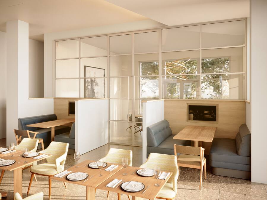 A modern dining area with glass partitions, wooden tables, and cushioned seating.